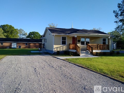 A house with a gravel driveway in front of it.