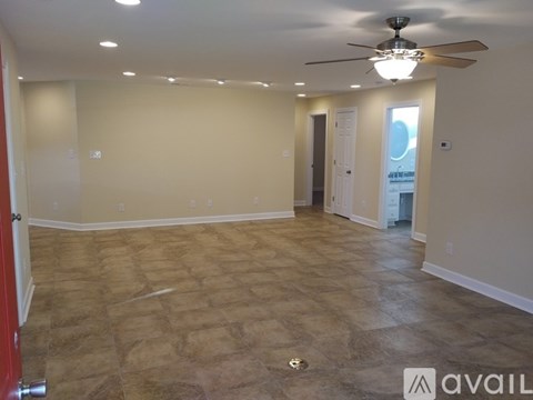 A spacious room with a ceiling fan and tiled floor.