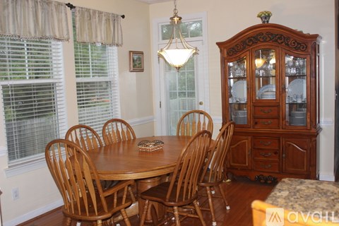 A dining room with a wooden table and chairs.