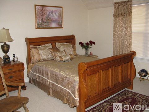 A bedroom with a large bed and a painting on the wall.