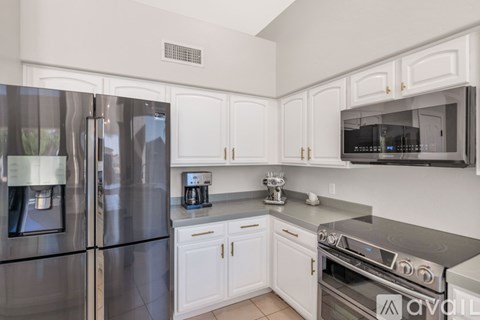 A kitchen with white cabinets and stainless steel appliances.