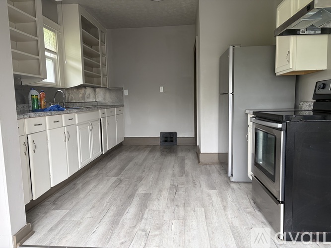 A kitchen with white cabinets and a black oven.