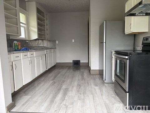 A kitchen with white cabinets and a black oven.