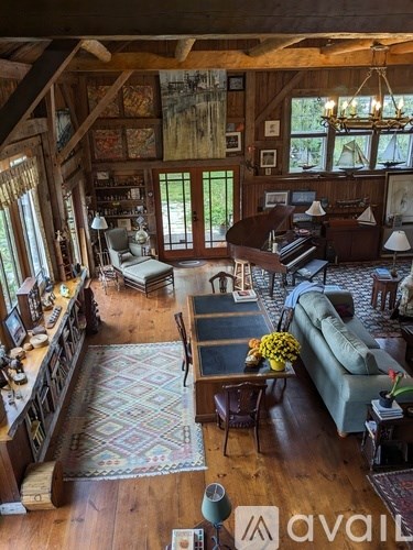 A living room with a couch, chairs, and a rug.