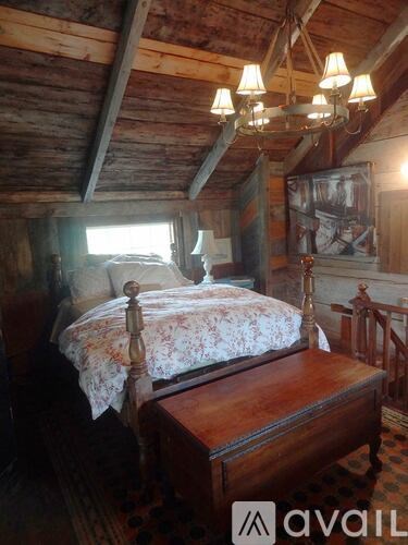 A bedroom with a bed and a chandelier.