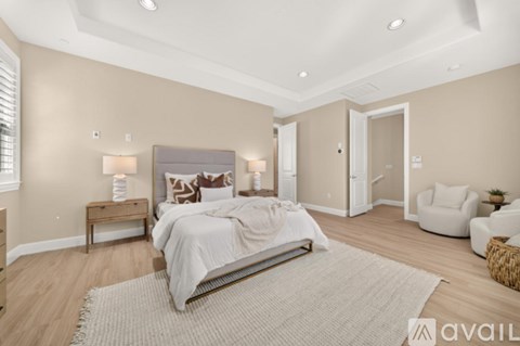 A bedroom with a bed, nightstands, and a chair.