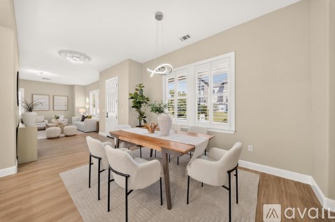 A dining room with a wooden table and chairs.