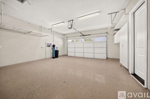 A spacious room with a carpeted floor, white walls, and a white door on the right side.