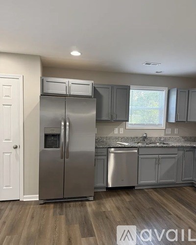 A kitchen with a stainless steel refrigerator and cabinets.
