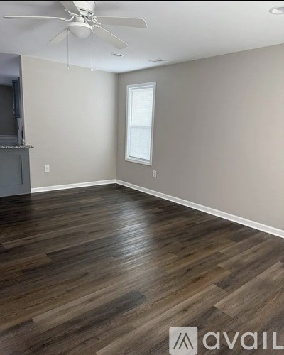 A room with wooden flooring and a ceiling fan.