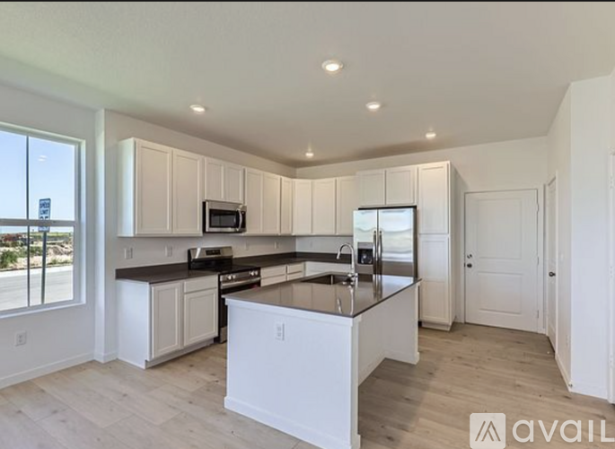 A modern kitchen with white cabinets and a large island.