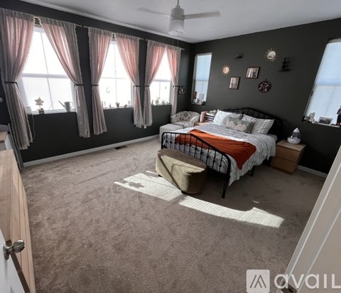 A bedroom with a large bed and a window with curtains.