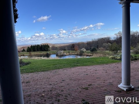 A view from a porch looking out over a pond and trees.