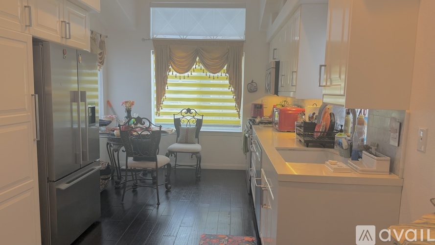 A kitchen with a table and chairs in front of a window.