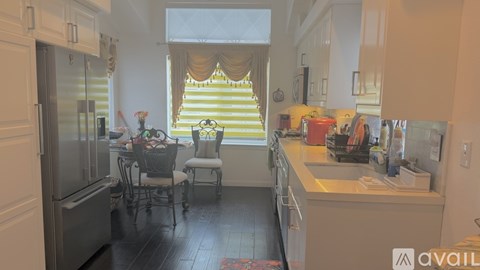 A kitchen with a table and chairs in front of a window.