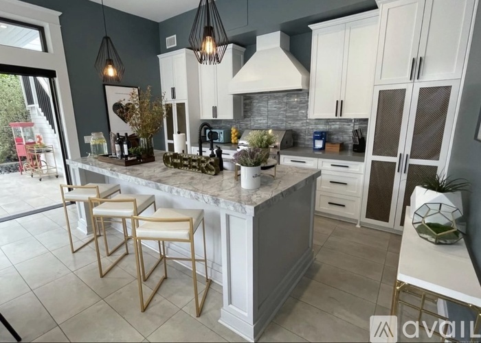 A kitchen with a marble countertop and bar stools.