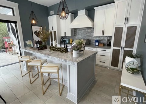 A kitchen with a marble countertop and bar stools.