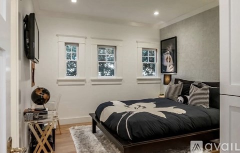 A bedroom with a large bed and a flat screen TV mounted on the wall.