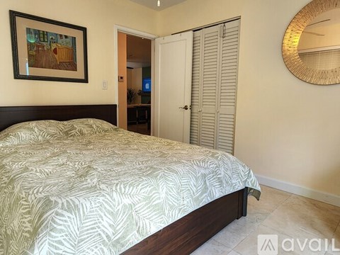 A bedroom with a large bed and a painting on the wall.