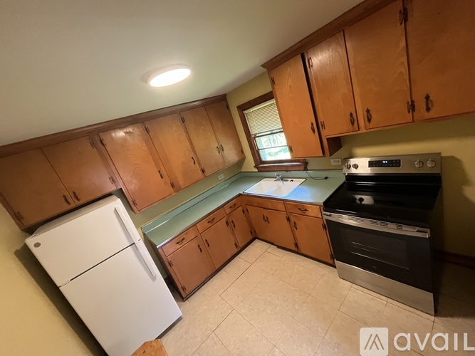 A kitchen with wooden cabinets and a white fridge.
