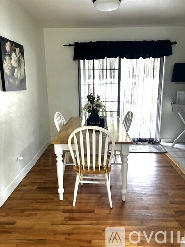A dining room with a wooden table and chairs.