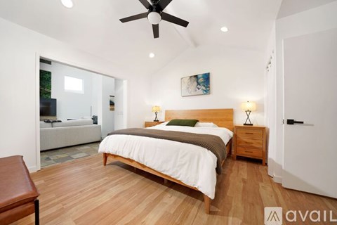 A bedroom with a bed, nightstand, and a ceiling fan.