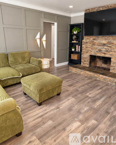 A living room with a green couch and a fireplace.