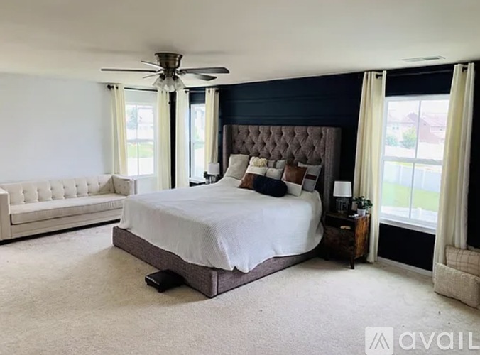 A bedroom with a large bed and a white couch.