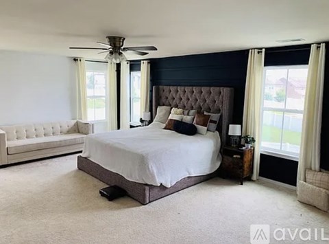 A bedroom with a large bed and a white couch.