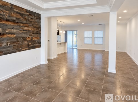 A spacious room with a stone wall and tiled floor.