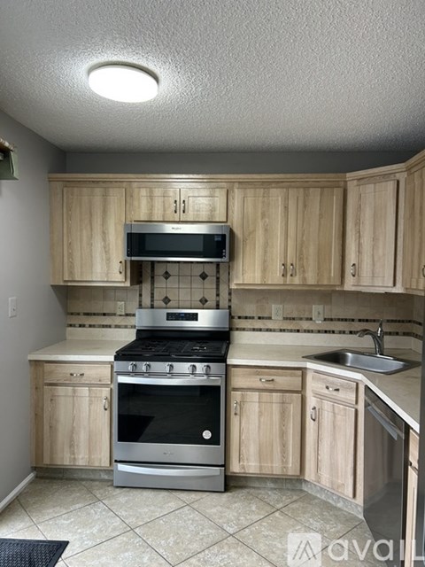 A kitchen with wooden cabinets and a stainless steel oven.