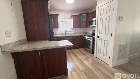 A kitchen with wooden cabinets and a granite countertop.