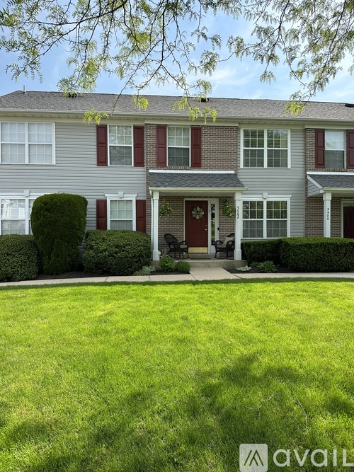 A house with a red door and windows is for sale.