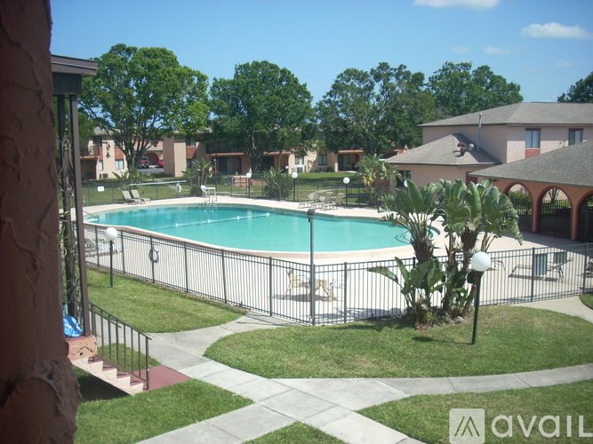 A pool surrounded by a fence and a green lawn.