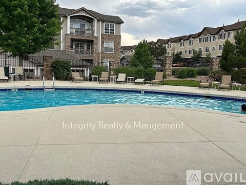 A large apartment complex with a pool in front.