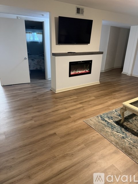 A living room with a fireplace and a television on the wall.