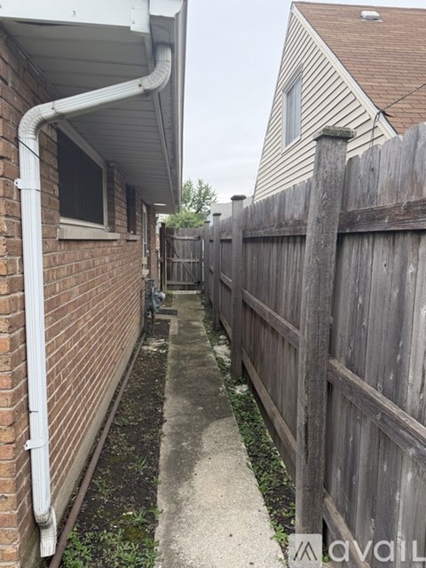 A white pipe runs along the side of a brick building.