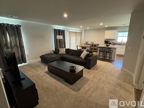 A living room with a black sofa and a coffee table.