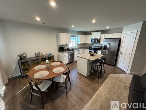 A kitchen with a table and chairs in the middle of the room.