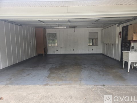 A large, empty garage with a concrete floor and white walls.