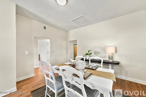 A dining room with a white table and chairs.