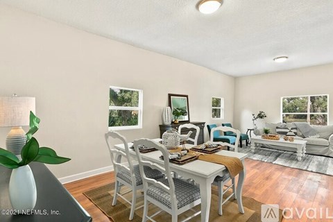 A living room with a dining table set up with chairs around it.