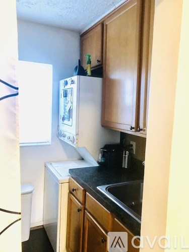 A kitchen with a white fridge and wooden cabinets.
