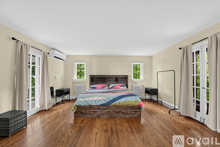 A bedroom with a large bed and wooden floors.