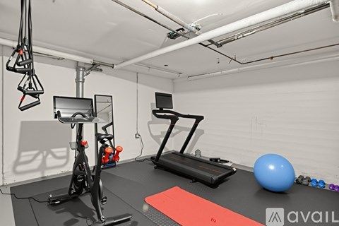 A gym with a treadmill, exercise bike, and other equipment.