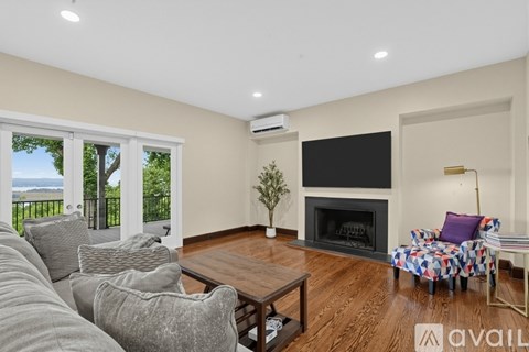 A living room with a fireplace and a television on the wall.
