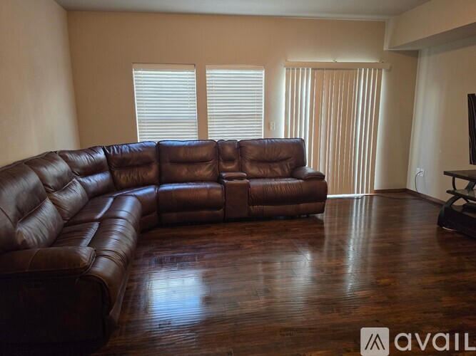 A brown leather sectional sofa in a living room.