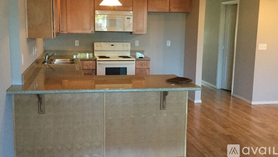 A kitchen with wooden cabinets and a granite countertop.
