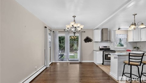 A kitchen with white cabinets and a wooden floor.