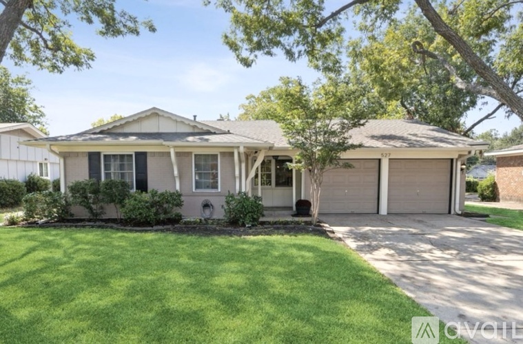A house with a well-maintained lawn and a tree in front.